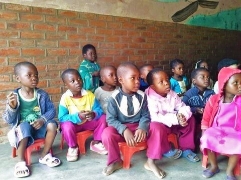 little children on little seats at daycare in Malawi