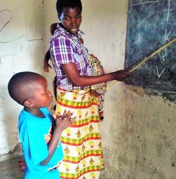 teacher pointing to blackboard at Malawi kindergarten funded by Brisbane charity Project Kindy