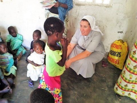 Sr Melissa Dwyer Canossian Sister helping a kindergarten child supported by Project Kindy in Brsibane